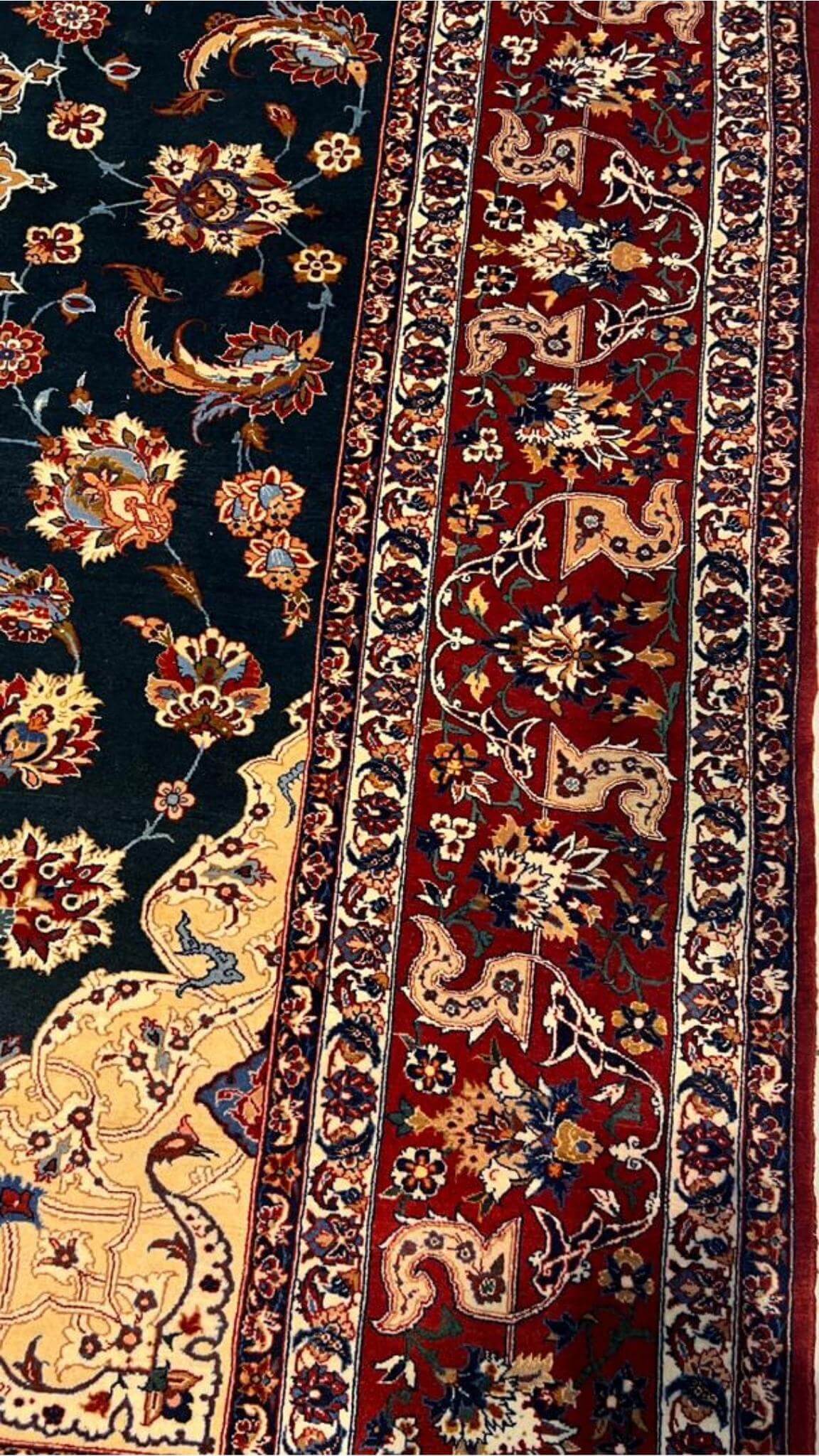 "Handcrafted wool and silk Persian rug with emerald green, gold, and red accents."